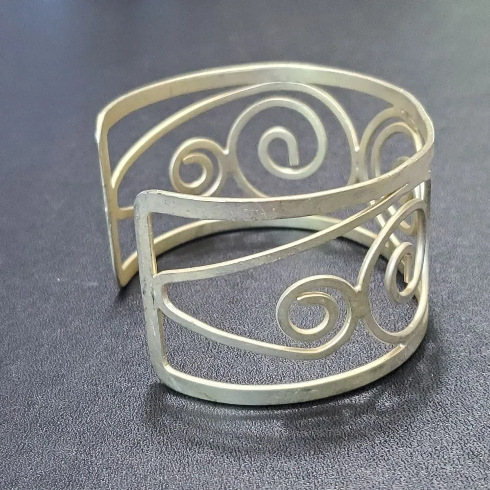 Gold tone swirly bangle cuff bracelet